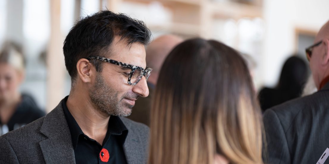 A man in glasses reading a card.