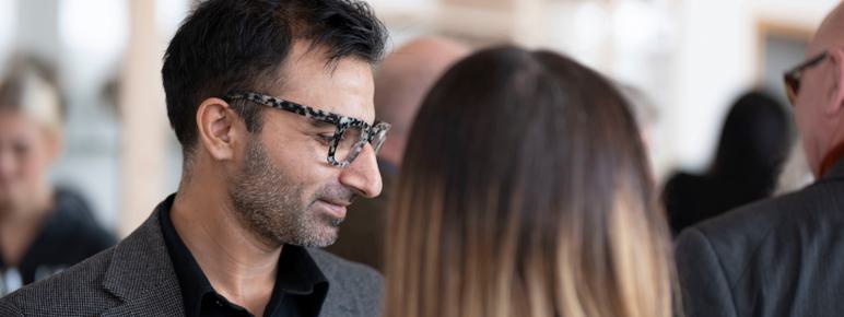 A man in glasses reading a card.