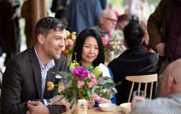 A couple sat at a table listening to a conversation.