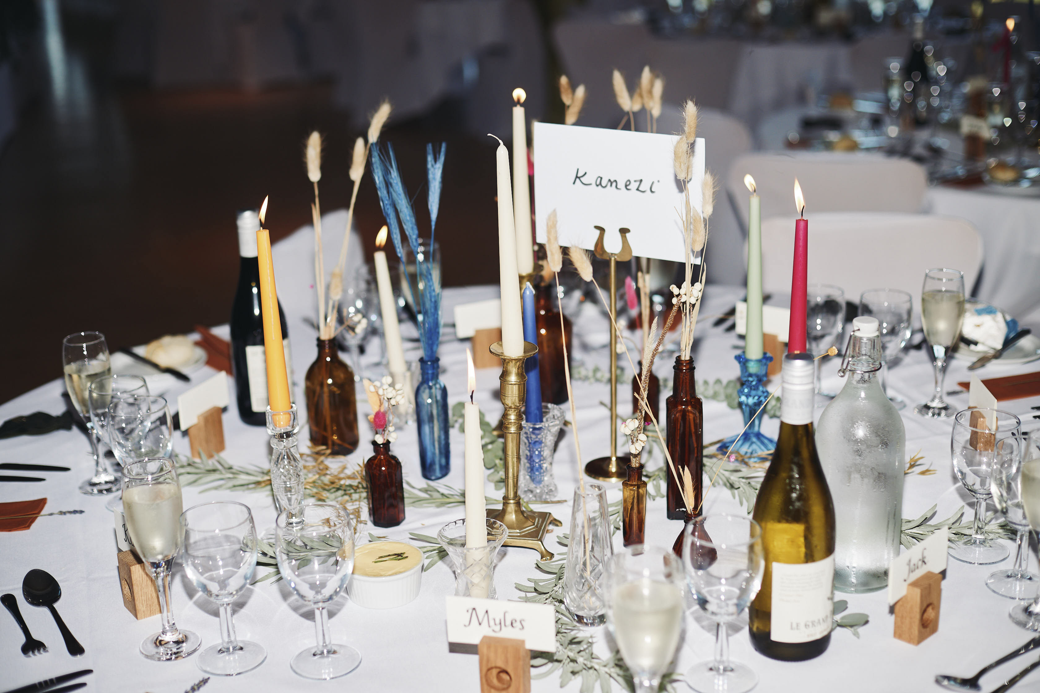 A table, set with glasses candles and wedding favours.