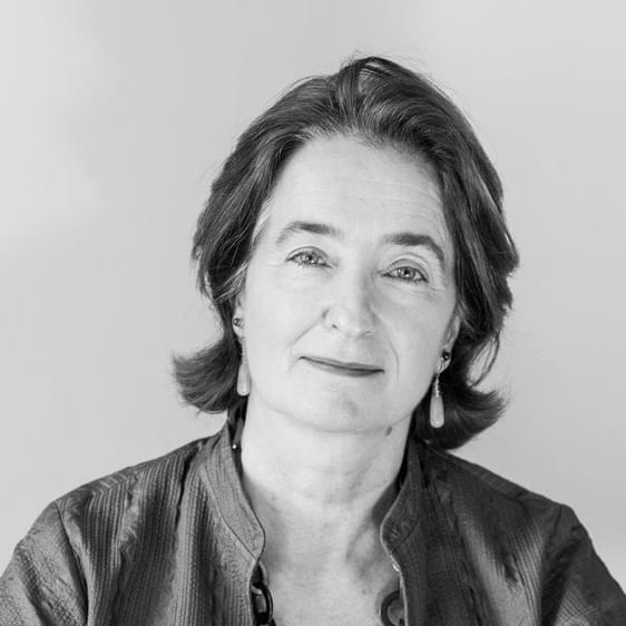 Headshot of a white woman wearing dangly earrings