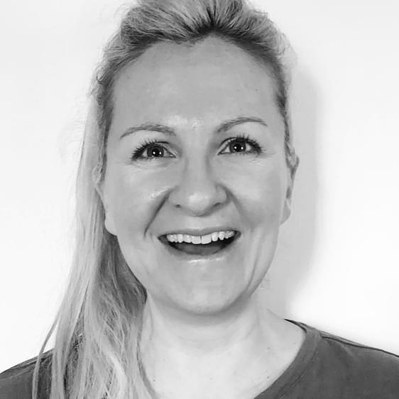 A black and white photo of a smiling woman with long blonde hair.