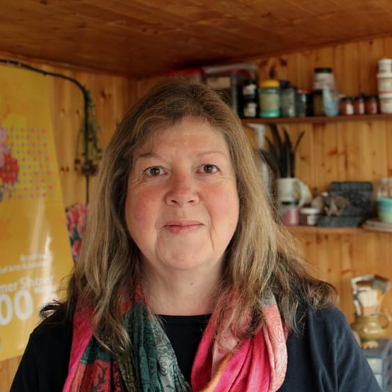 A woman with long brown hair in a pottery studio