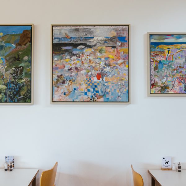 Three framed abstract paintings depicting birds and foliage, displayed on a white gallery wall.