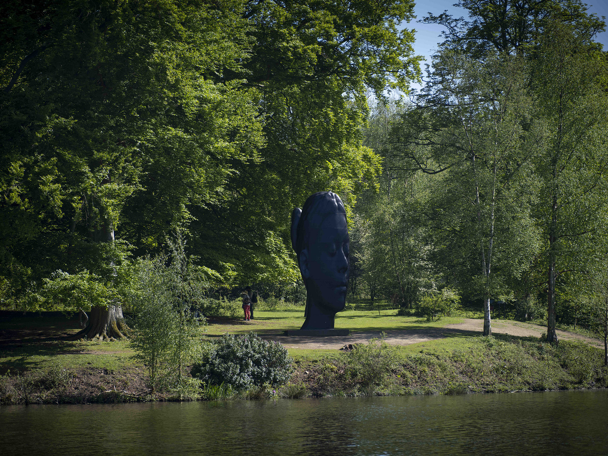 Jaume Plensa, Wilsis seen from across a lake at Yorkshire Sculpture Park