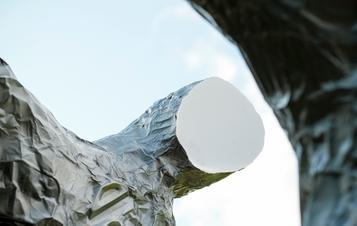 A close up of a silver figure with a flat featureless face