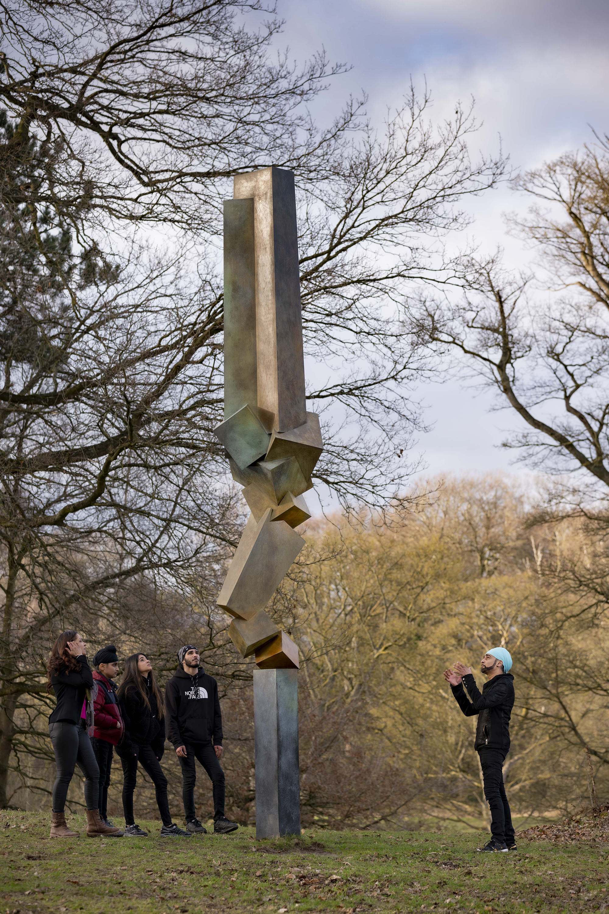 A group of people standing in front of Bruce Beasley Advocate IV, 1998, at Yorkshire Sculpture Park