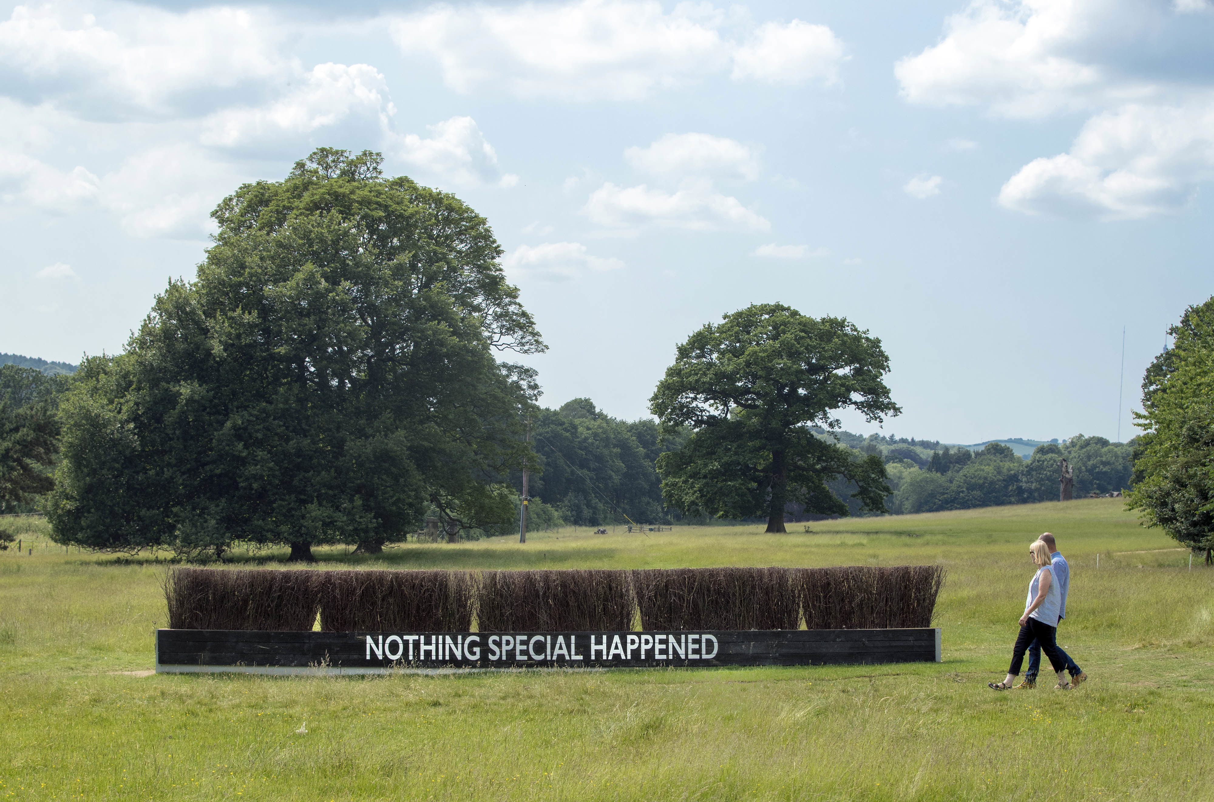Two visitors walking beside Katrina Palmer The Coffin Jump 2018 at Yorkshire Sculpture Park