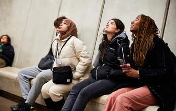 A group of young people inside the skyspace, looking up to the ceiling