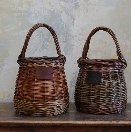 A pair of woven baskets displayed on a wooden table