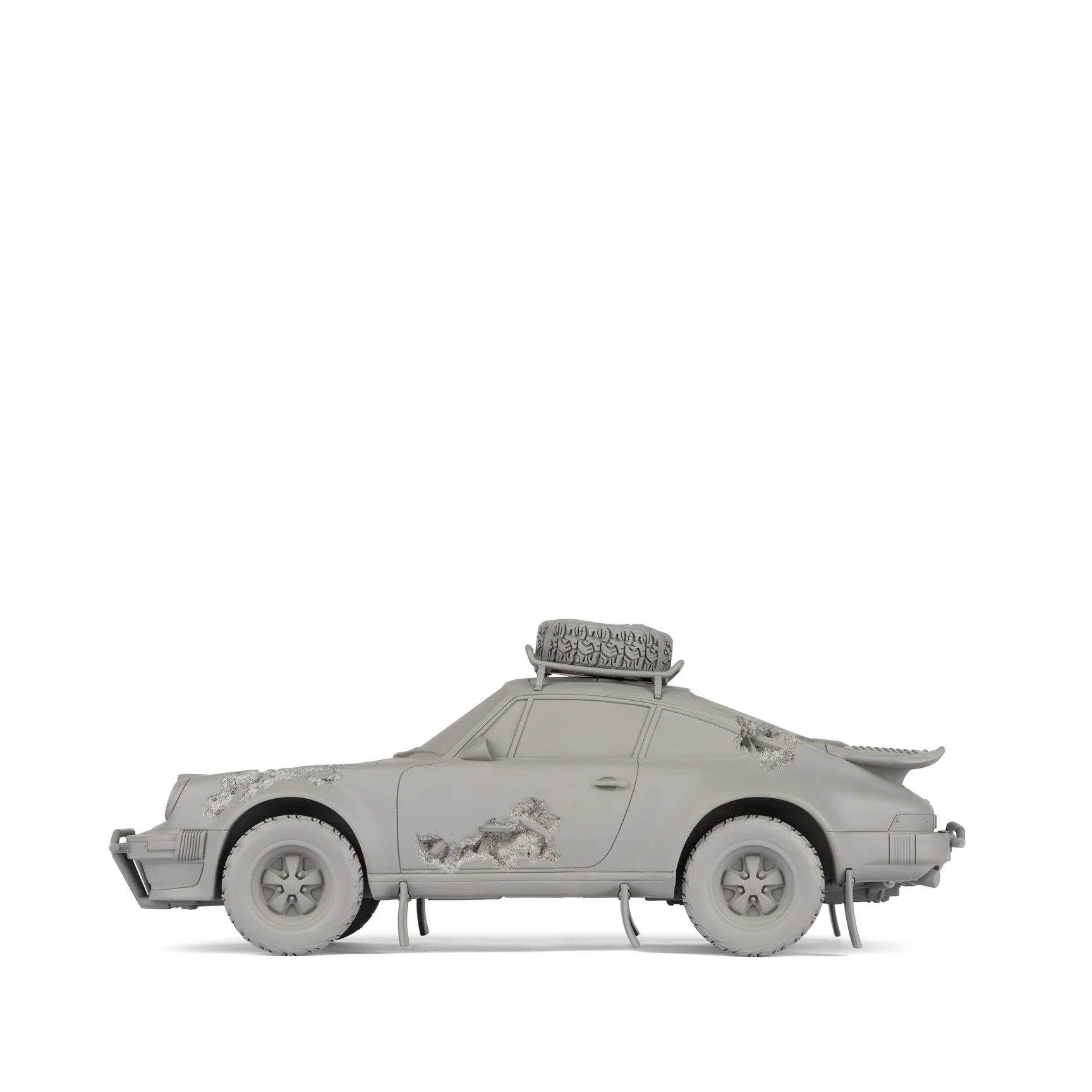 A sculpture of a grey car with eroded crystal sections.
