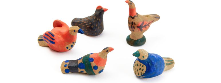 A collection of five small, colourful bird figurines. Each bird features unique patterns and colours, including red, blue, and natural tones, set against a plain white background. The figures vary in shape and design.
