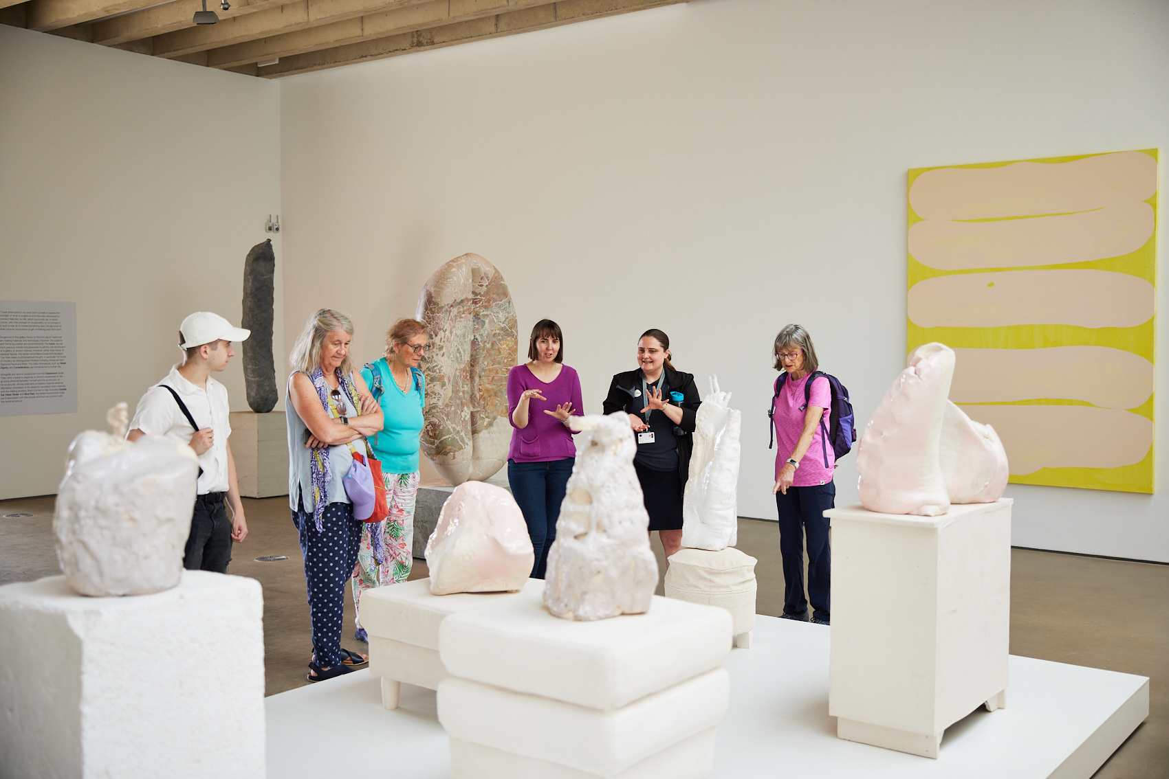 A group of people looking at abstract sculptures on plinths in a gallery space