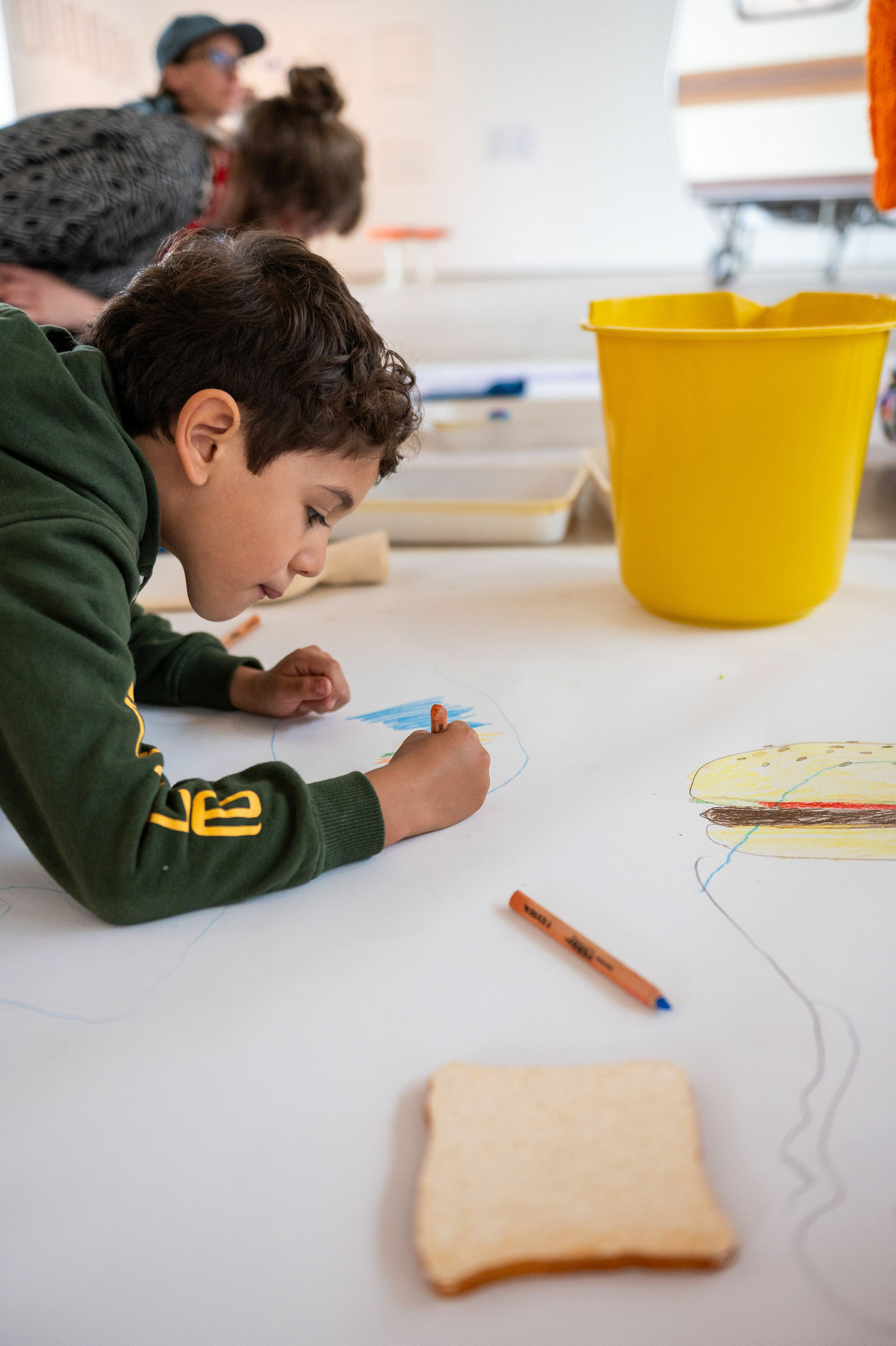 A child drawing on a large piece of paper