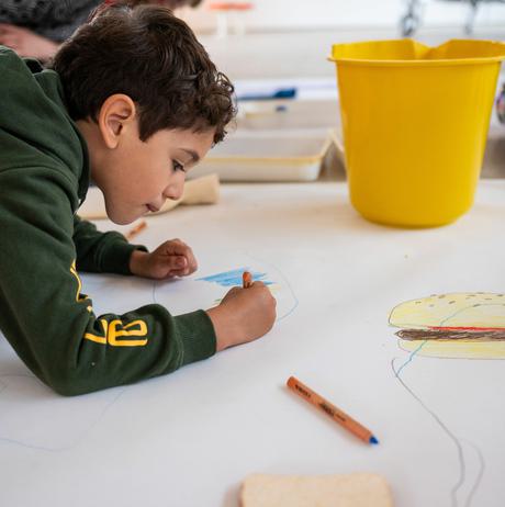 A child drawing on a large piece of paper
