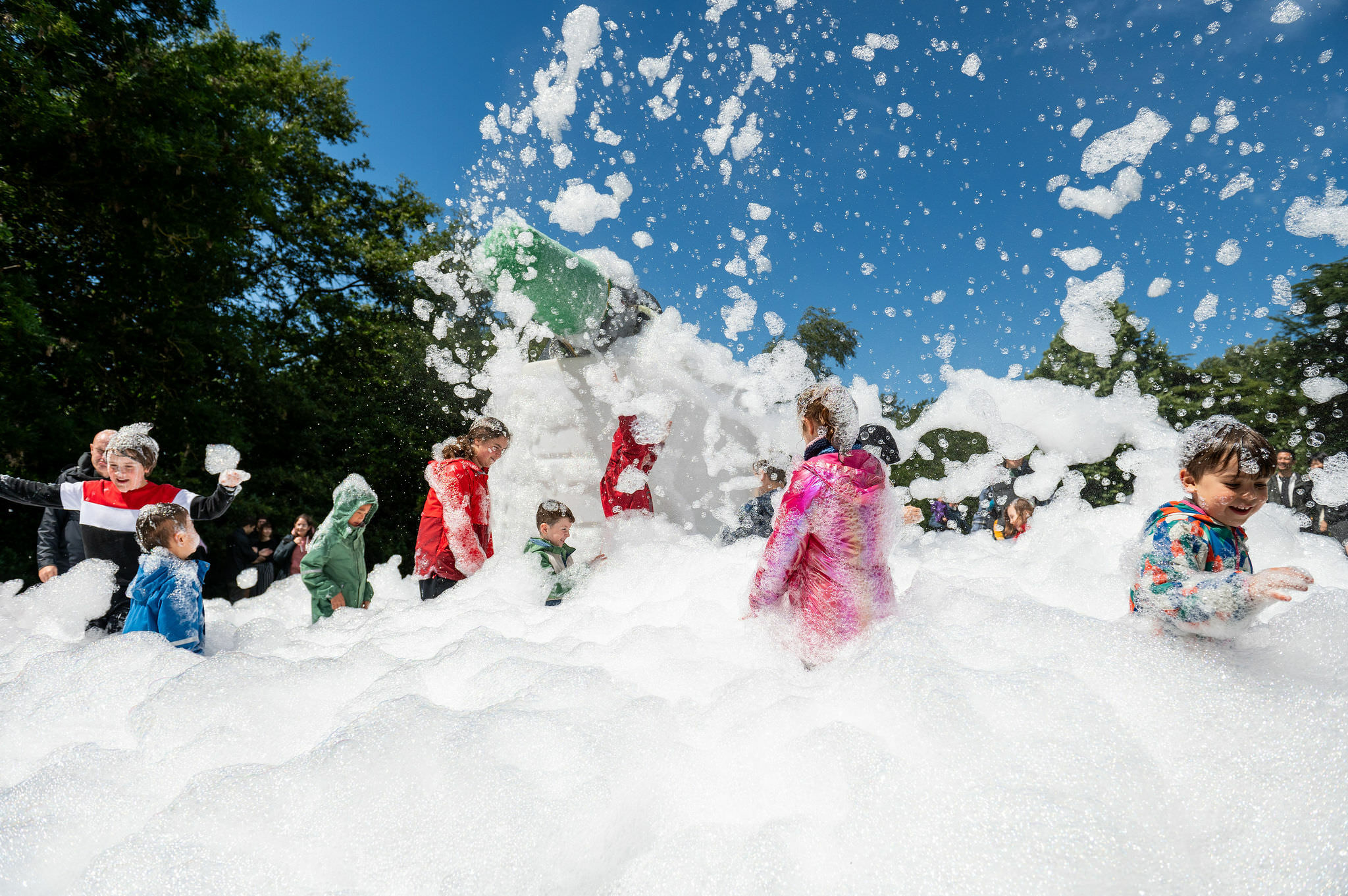 A group of children playing in a cloud of foam