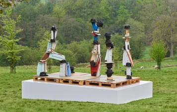 Four sculptures with fedora, boater and trilby hats resting on top.