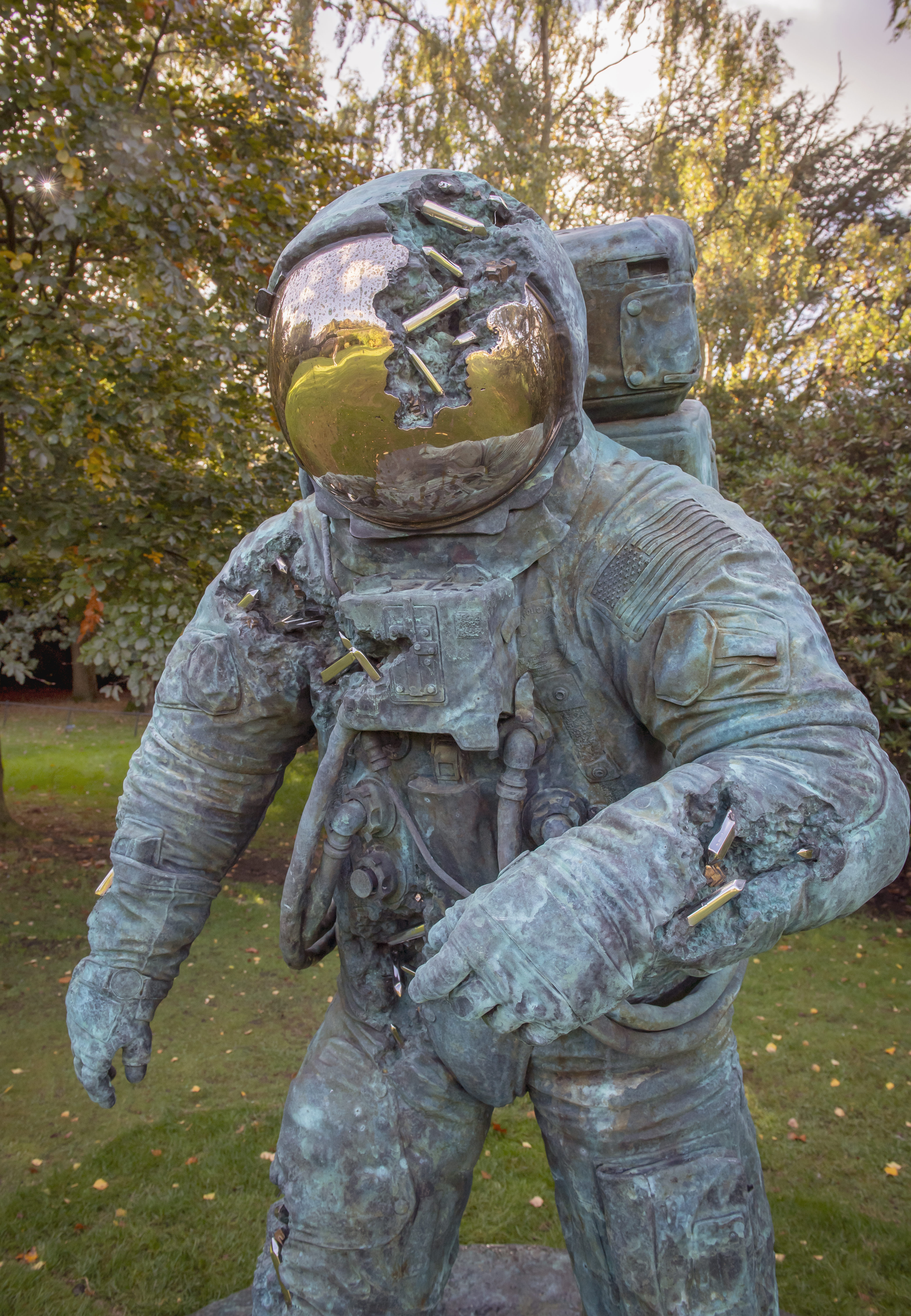 A bronze sculpture of an astronaut with crystal erosions coming out of the bronze.