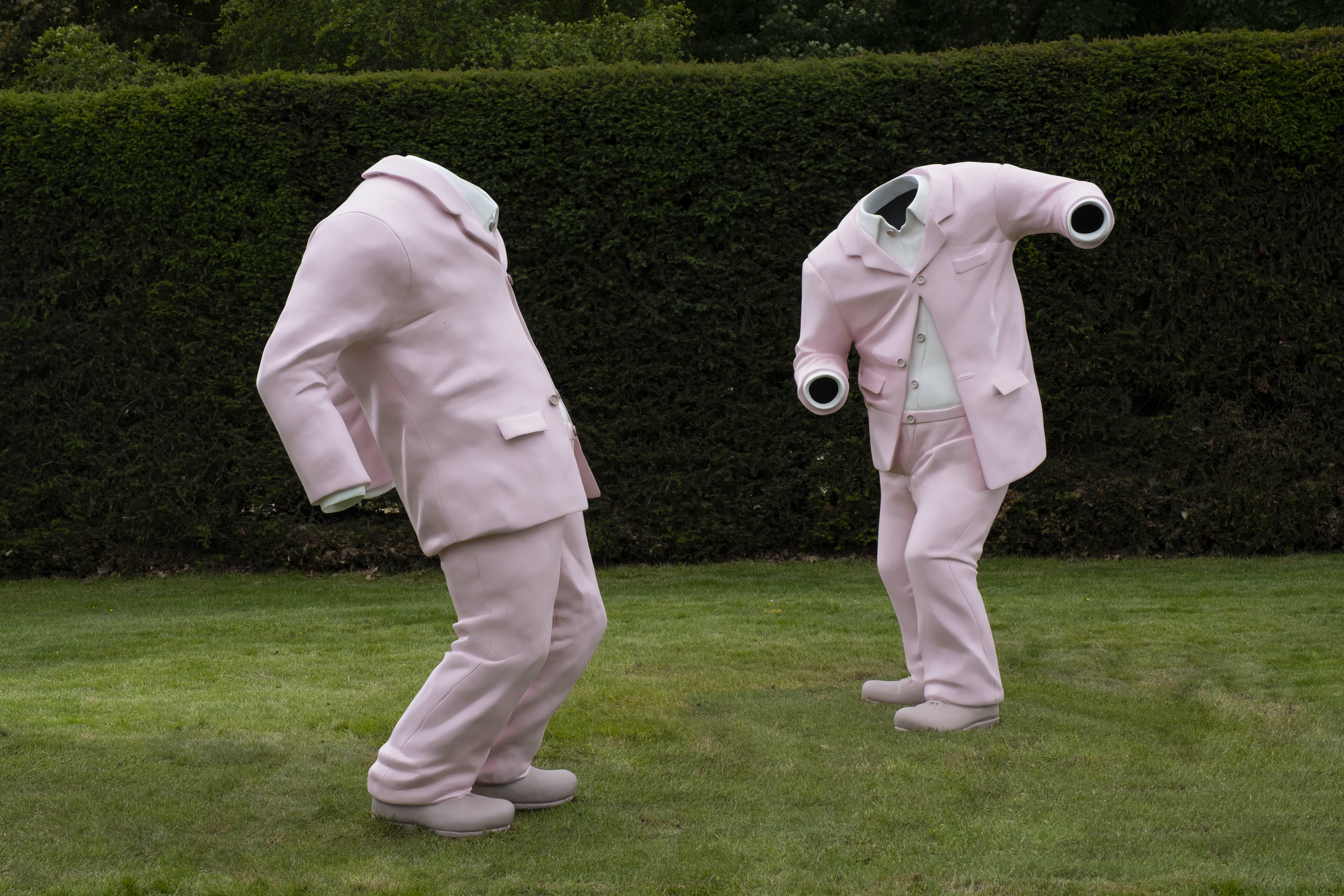 A sculpture of two dancing pink suits