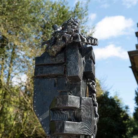 Close up of a bronze abstract figure outdoors.