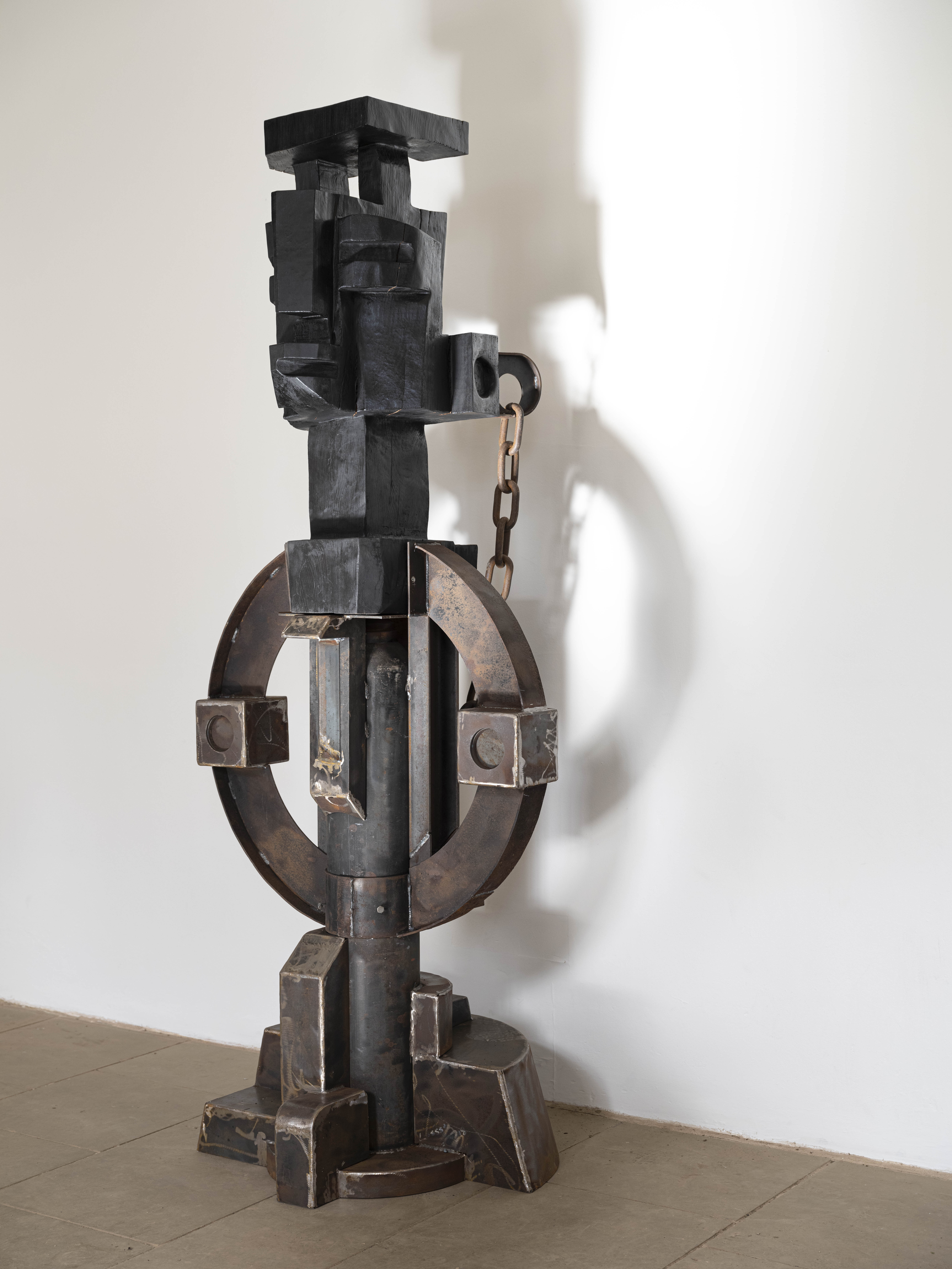 A carved wood and welded metal totem