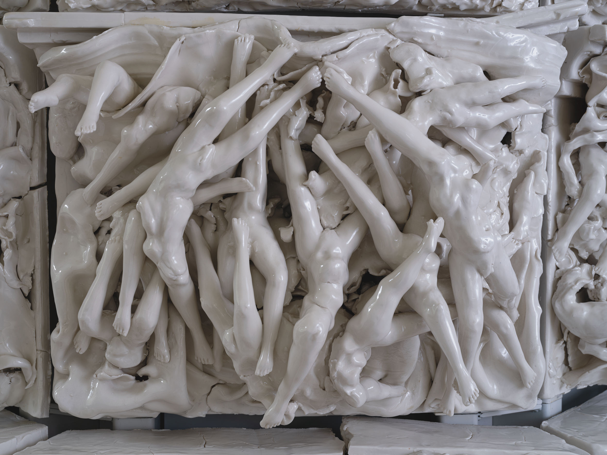 Porcelain tile of torsos and legs intertwined.