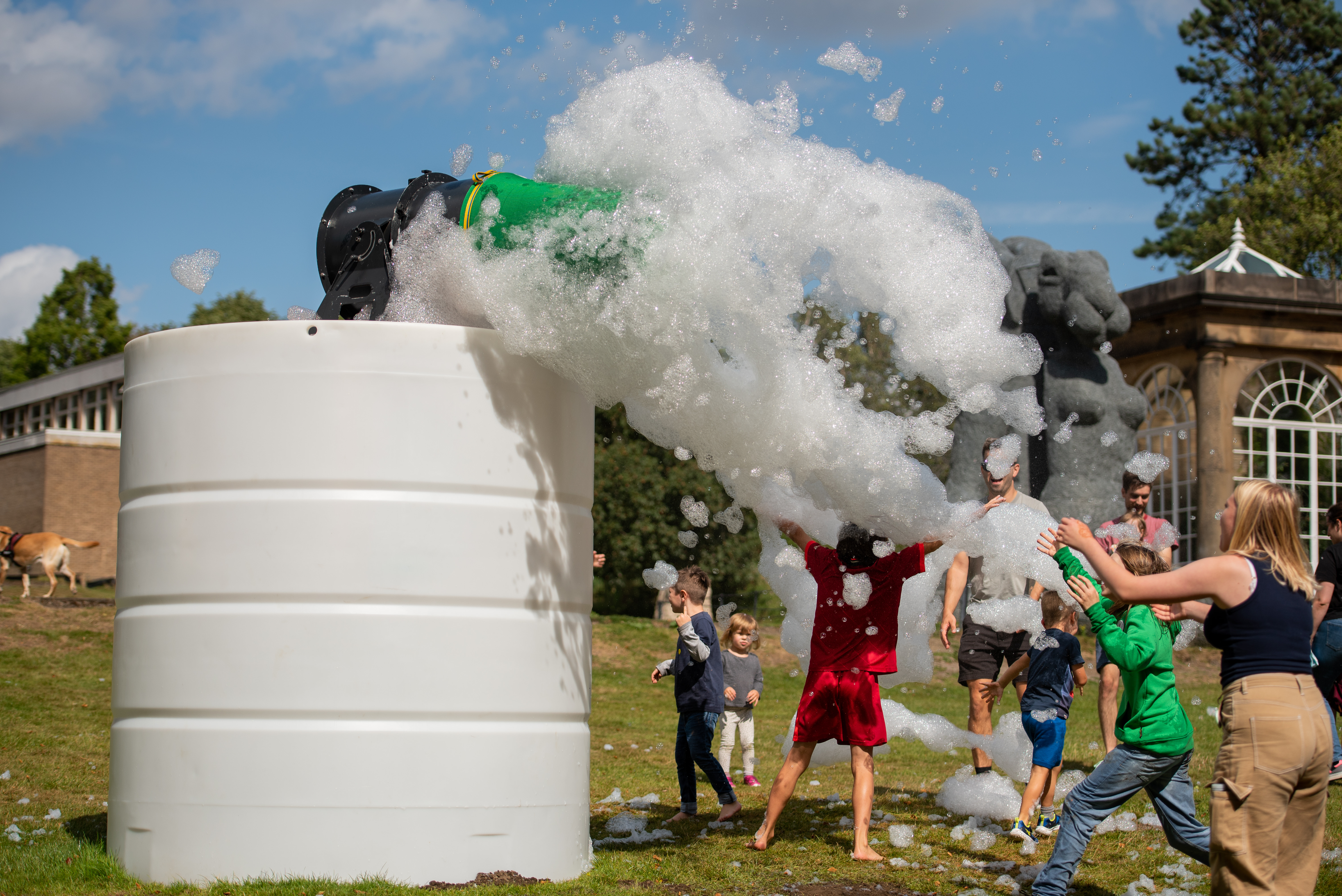 A group of people playing in a cloud of foam outdoors