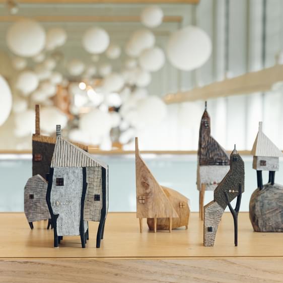 A display of miniature carved wooden houses.