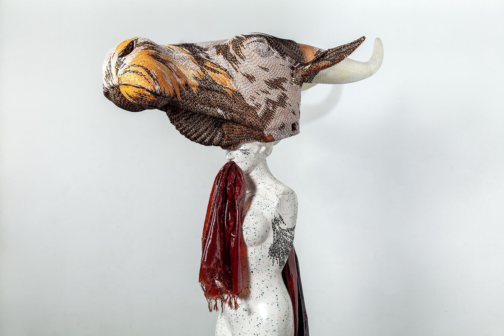 A sculpture of a woman with a giant cows head.