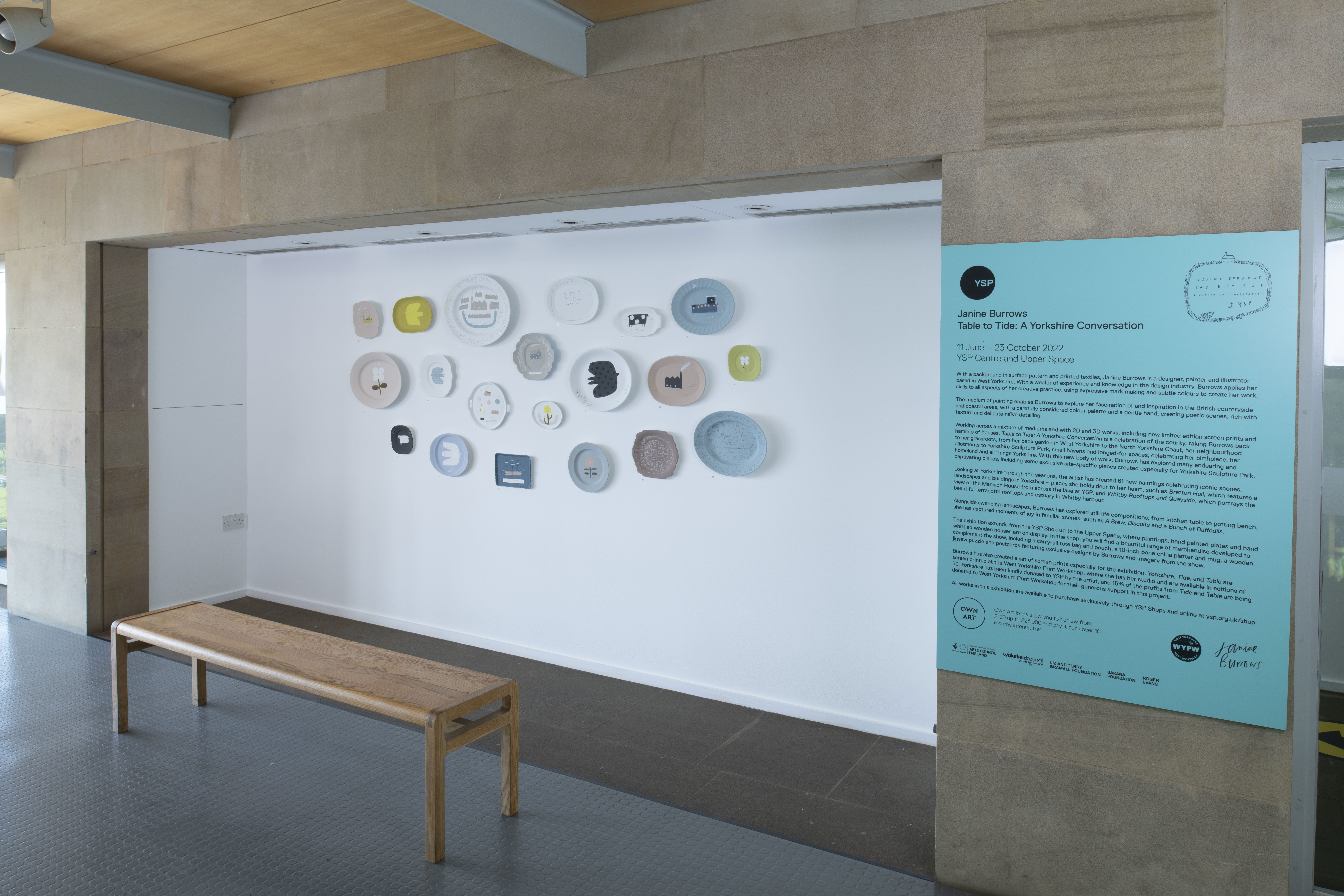 Twenty plates hung and exhibition text on wall of upper gallery space at YSP.