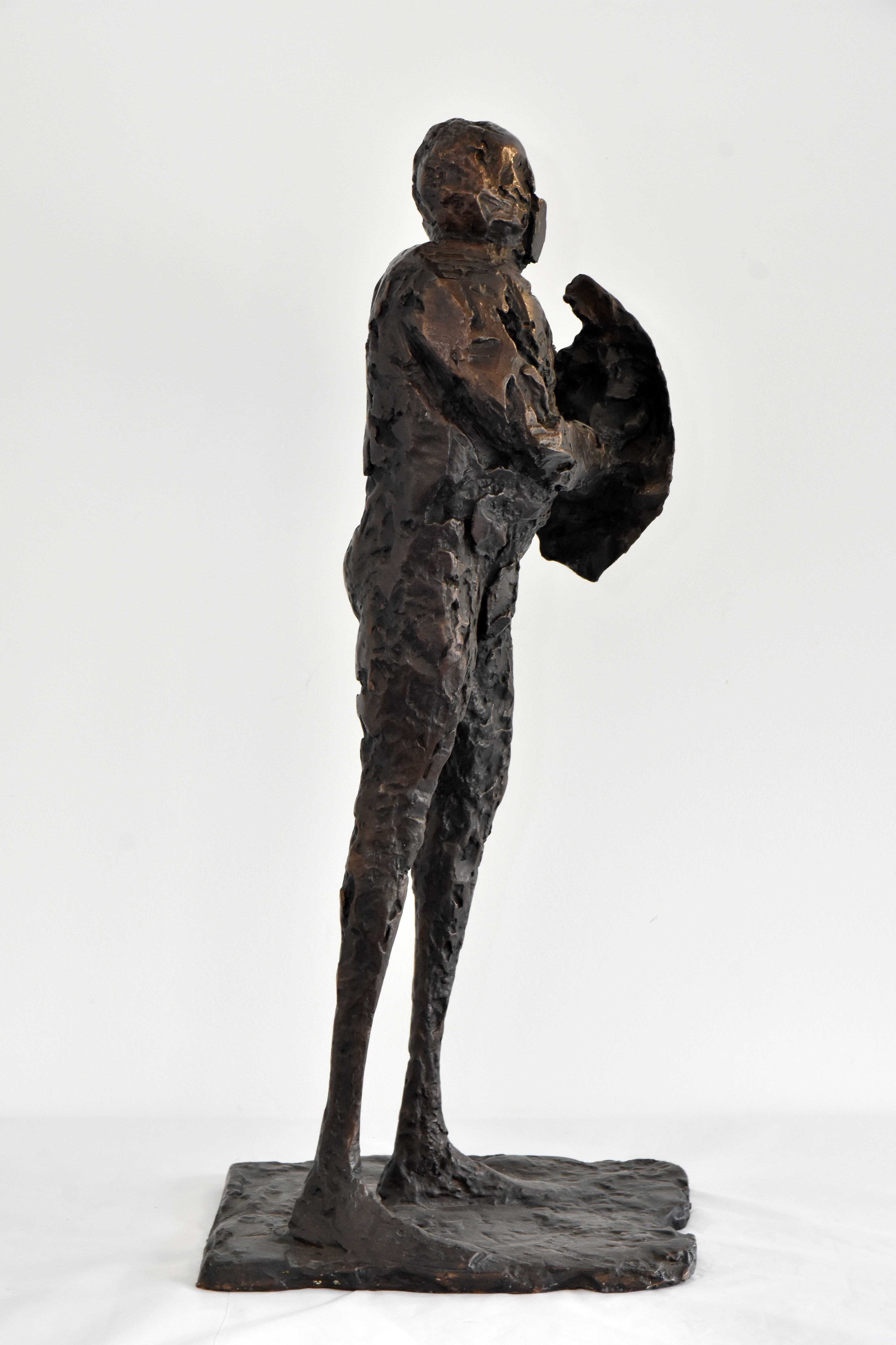 A bronze sculpture of a standing man, holding a shield.