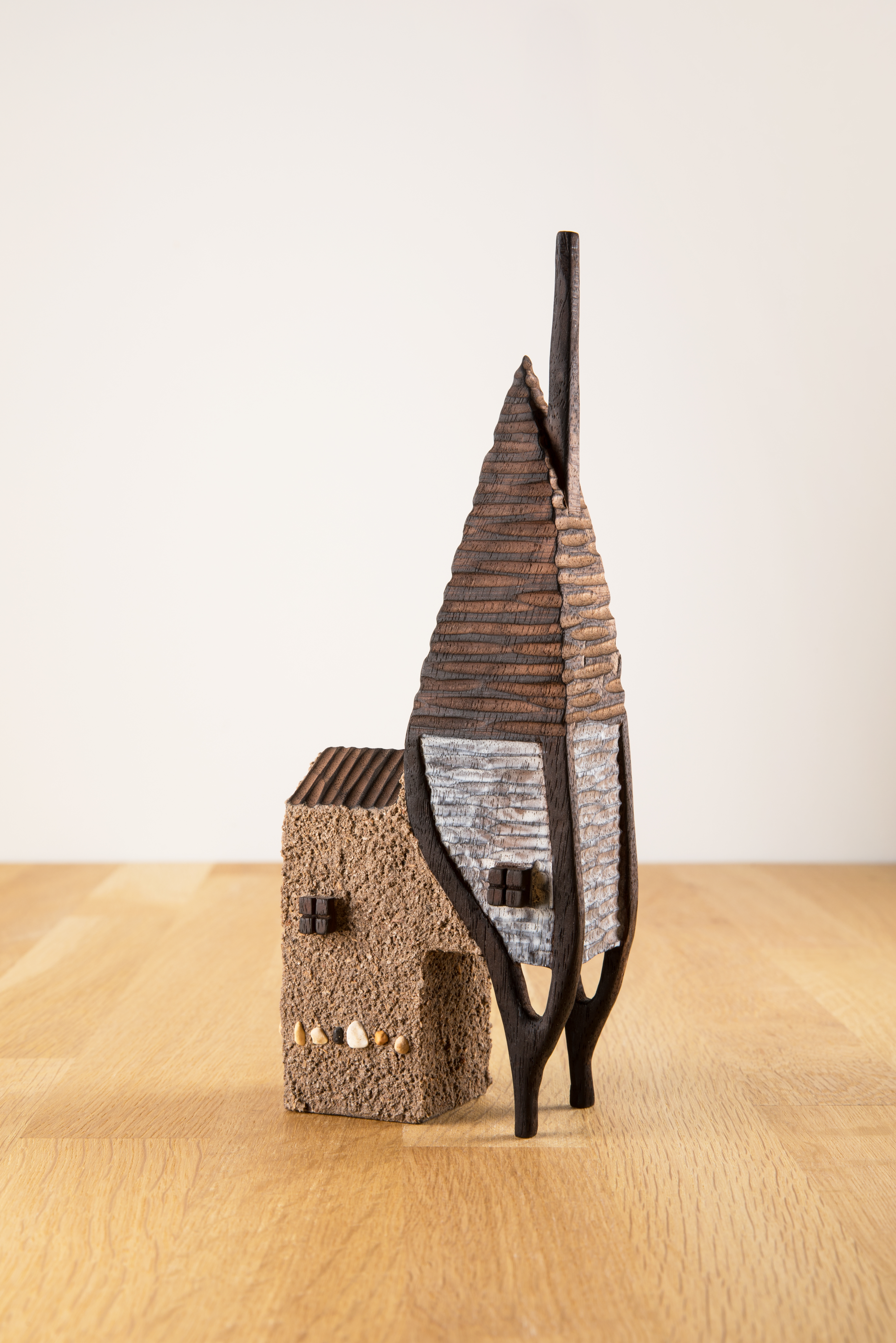 A miniature carved wooden house, with tall chimney