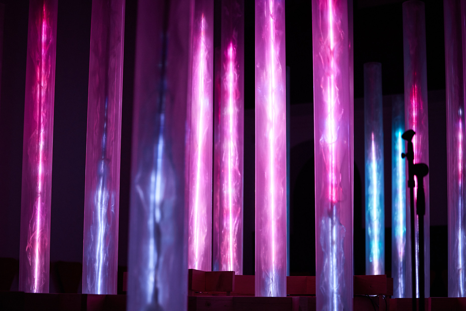 An installation of pink and blue glowing columns.