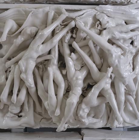 Porcelain tile of torsos and legs intertwined.