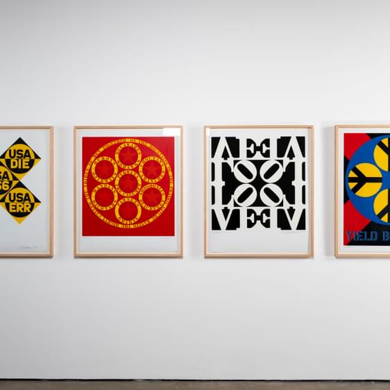 Four paintings hung in a row on the wall.