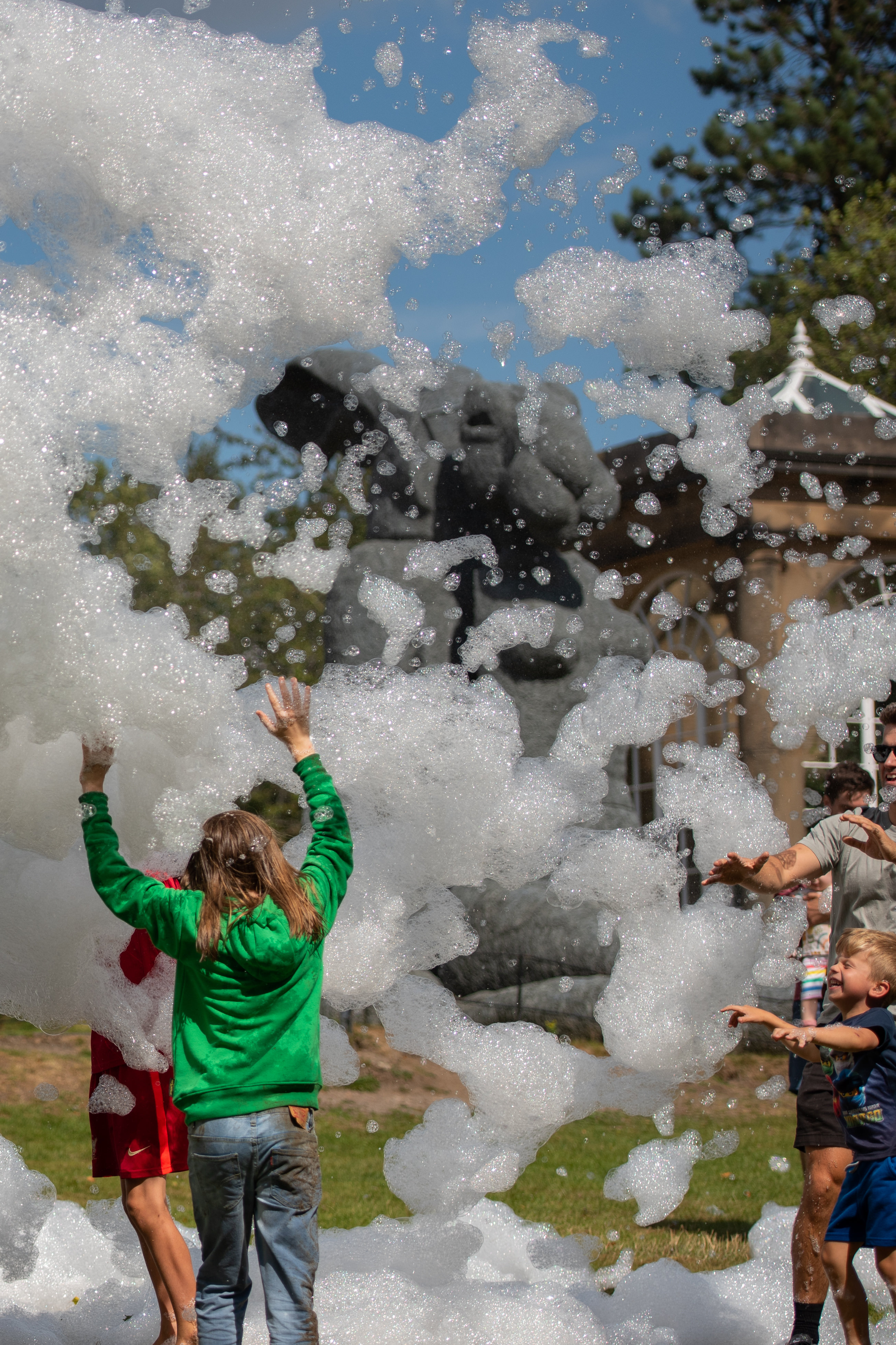 A group of people playing in a cloud of foam outdoors