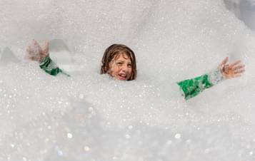 A child playing in a cloud of foam