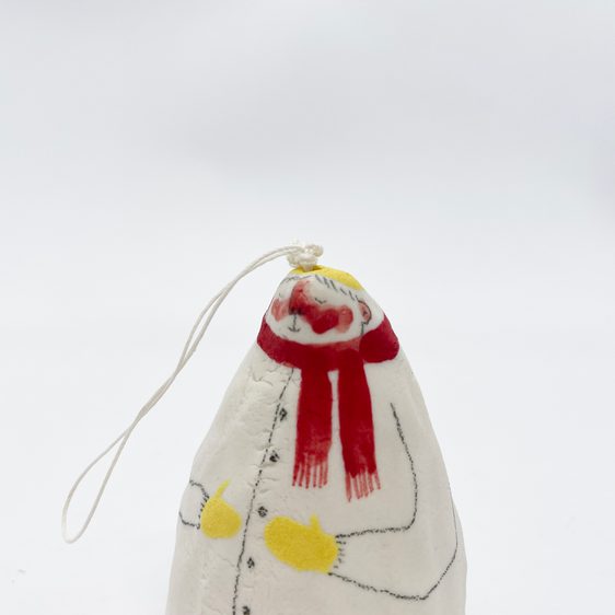 A porcelain bell ornament, painted to show a figure wearing a winter scarf