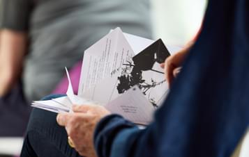 A close up of a person's hands opening a 3D folder book
