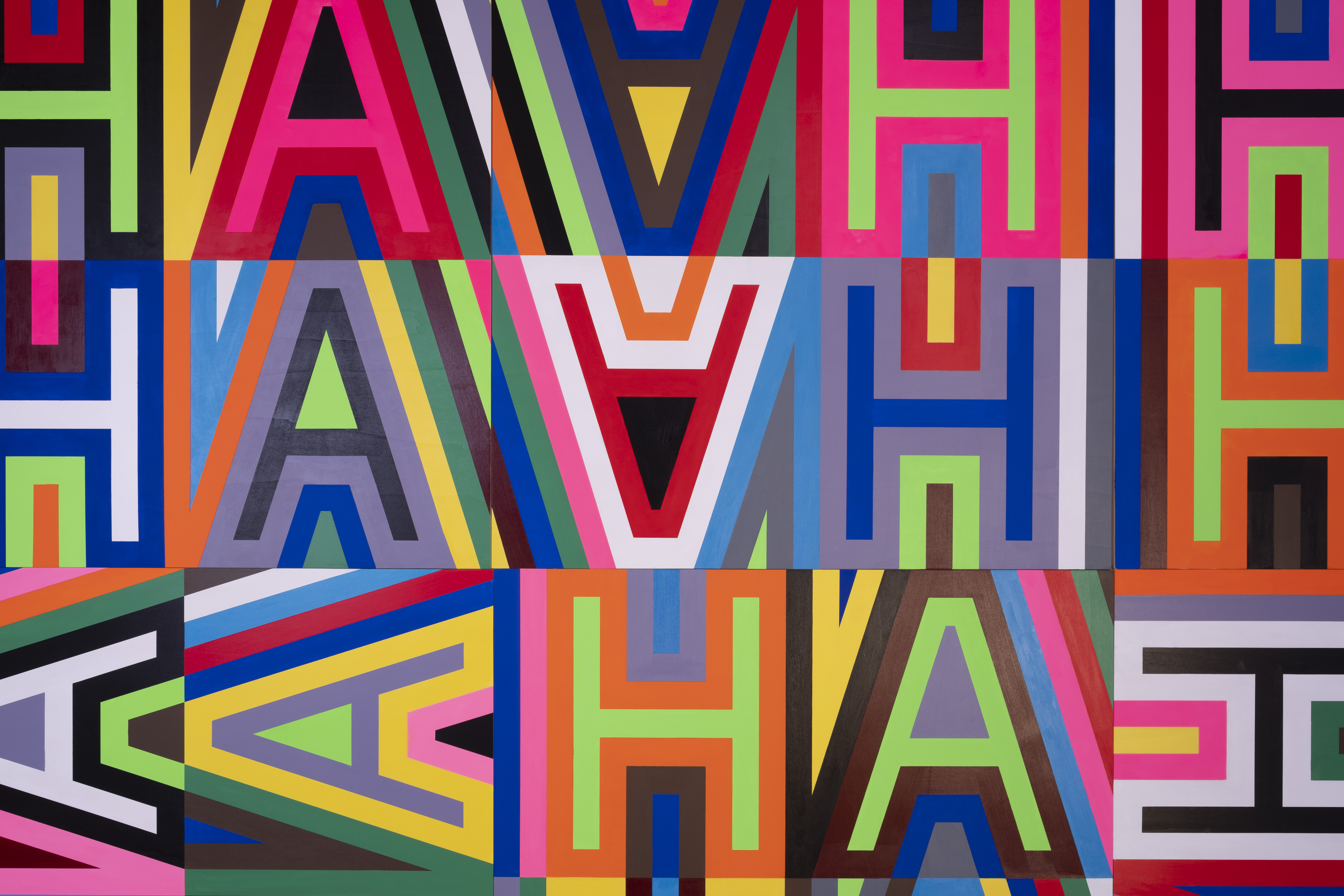 A close up of a brightly coloured graphic letters which spell out the words HAHA in a repeating pattern.