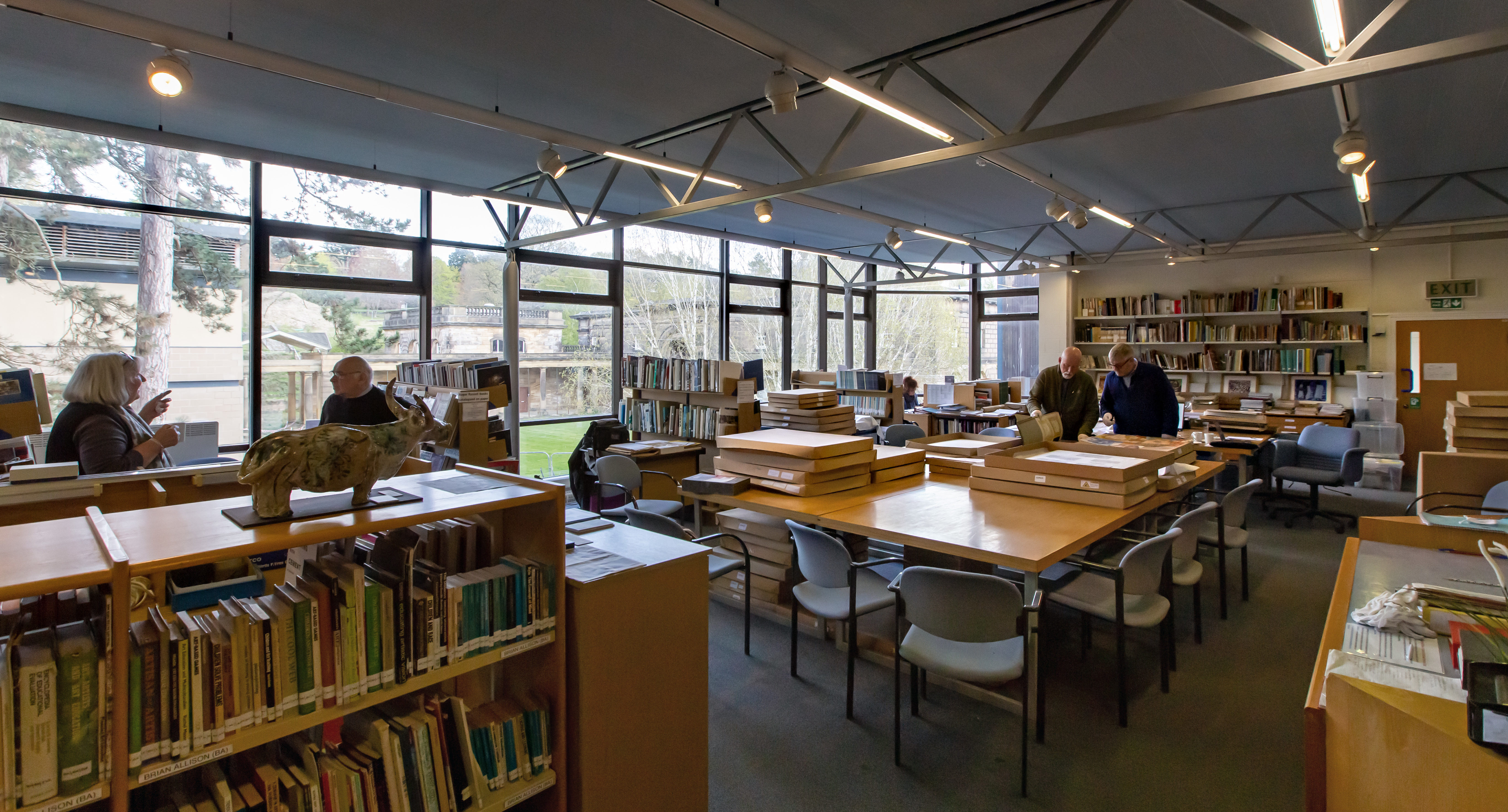Four people stood amongst bookshelves and tables in the National Arts Education Archive.