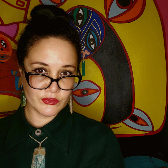 Head shot of a woman with dark hair in a bun and glasses.