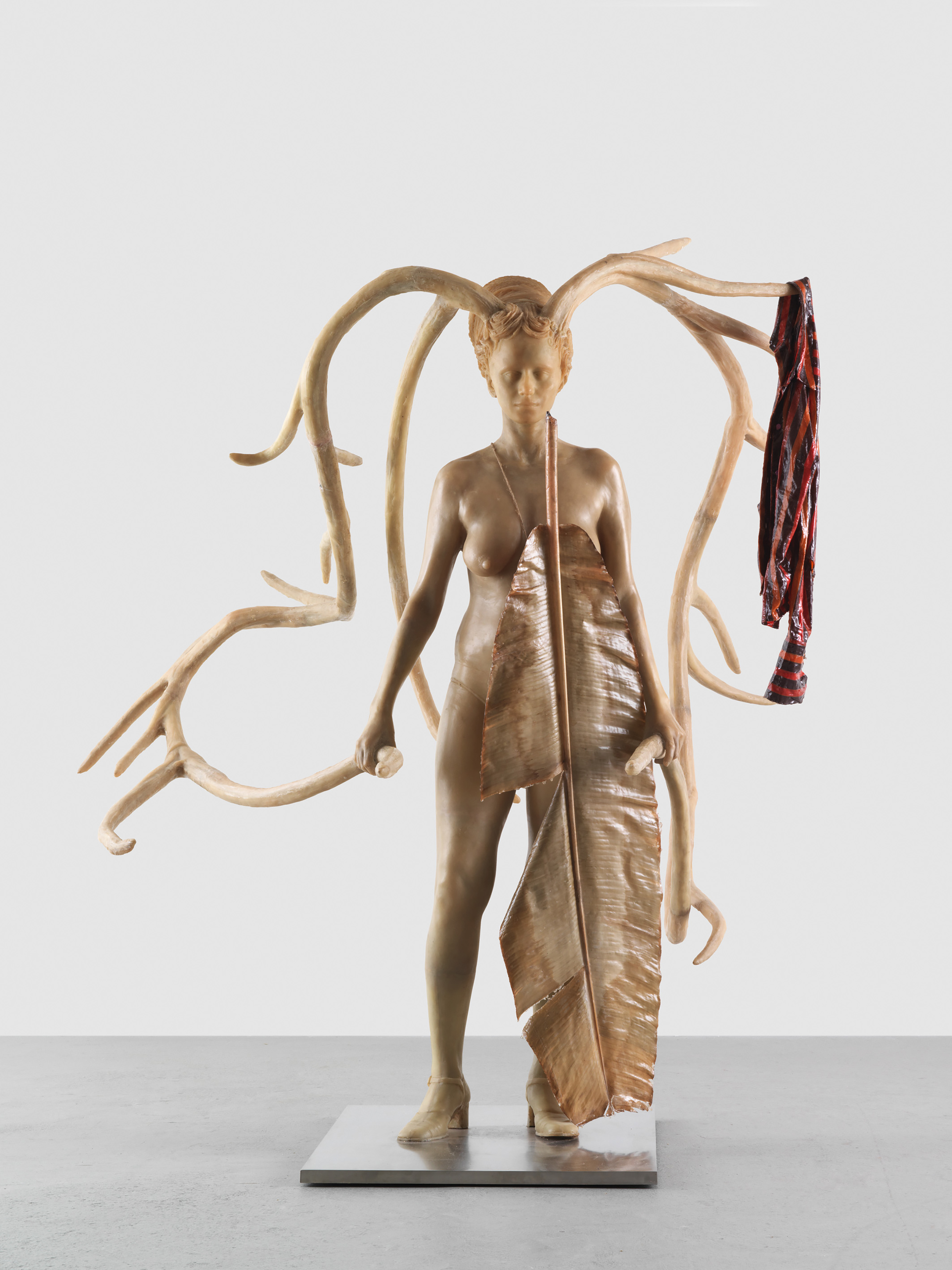 A white sculpture of a woman with extended antlers.