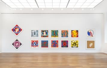A display of brightly coloured pop art prints in a gallery.