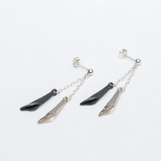 A pair of silver and black dangling earrings.