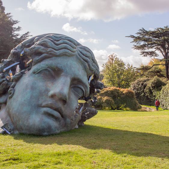 A large bronze sculpture of a woman's head, with eroded crystal sections.
