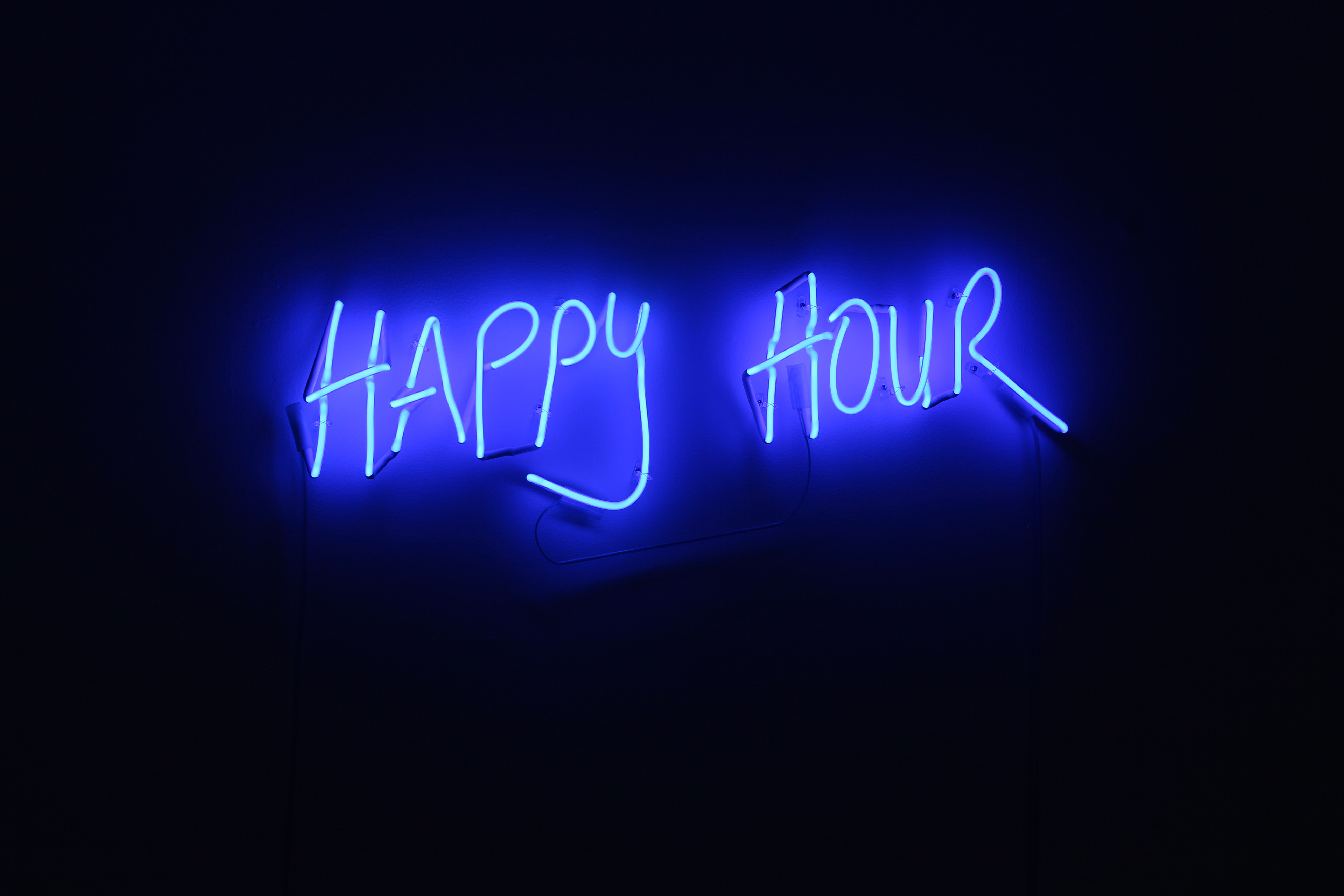 A blue neon sign reading HAPPY HOUR