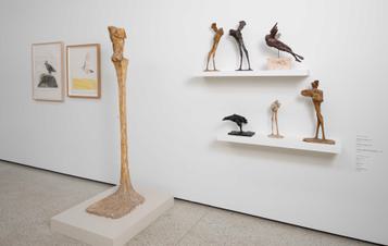 An exhibition of plaster models of animals displayed on shelves, and a to-scale model for a sculpture displayed on a plinth.