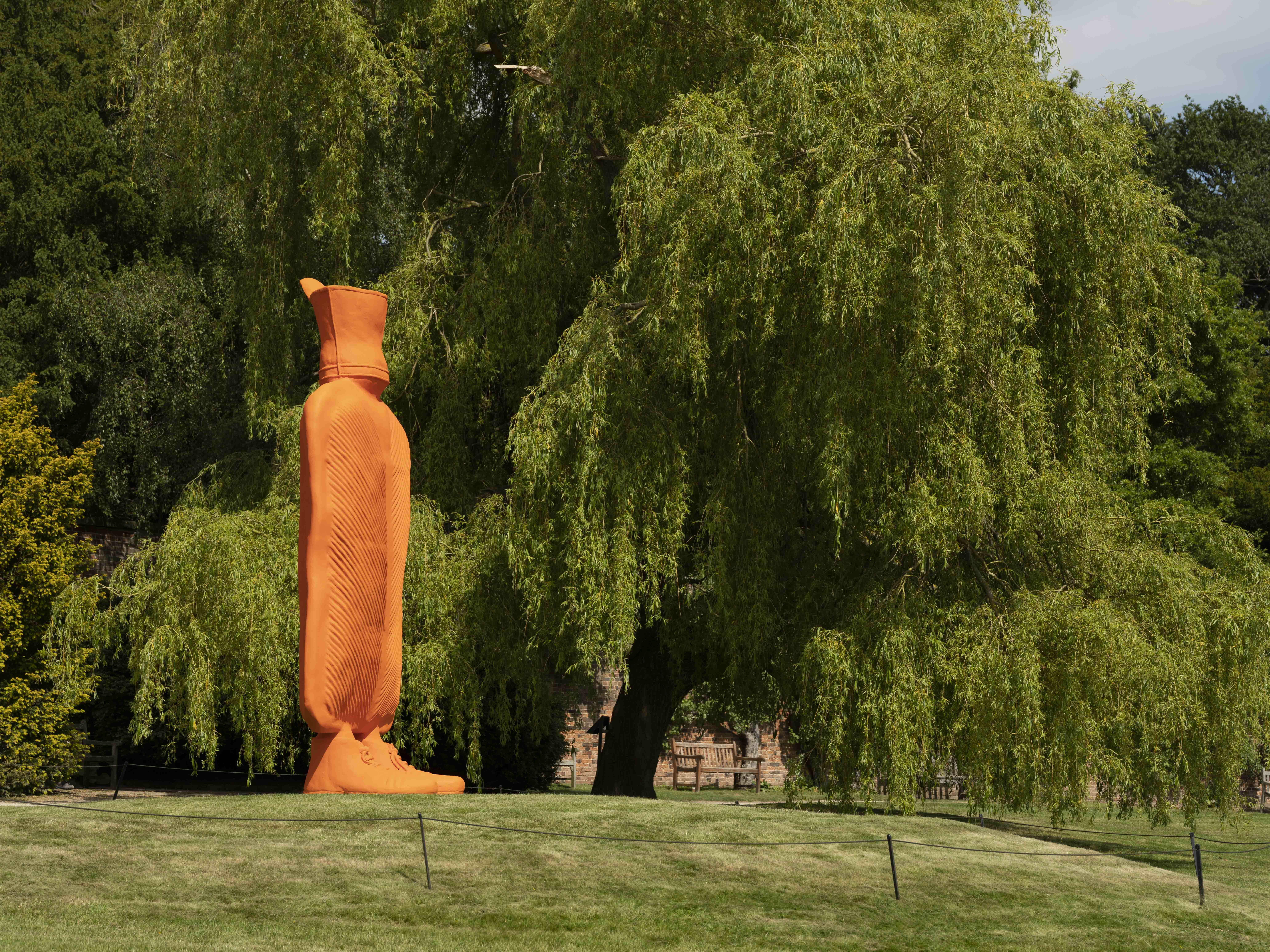 A giant orange hot water bottle on grass