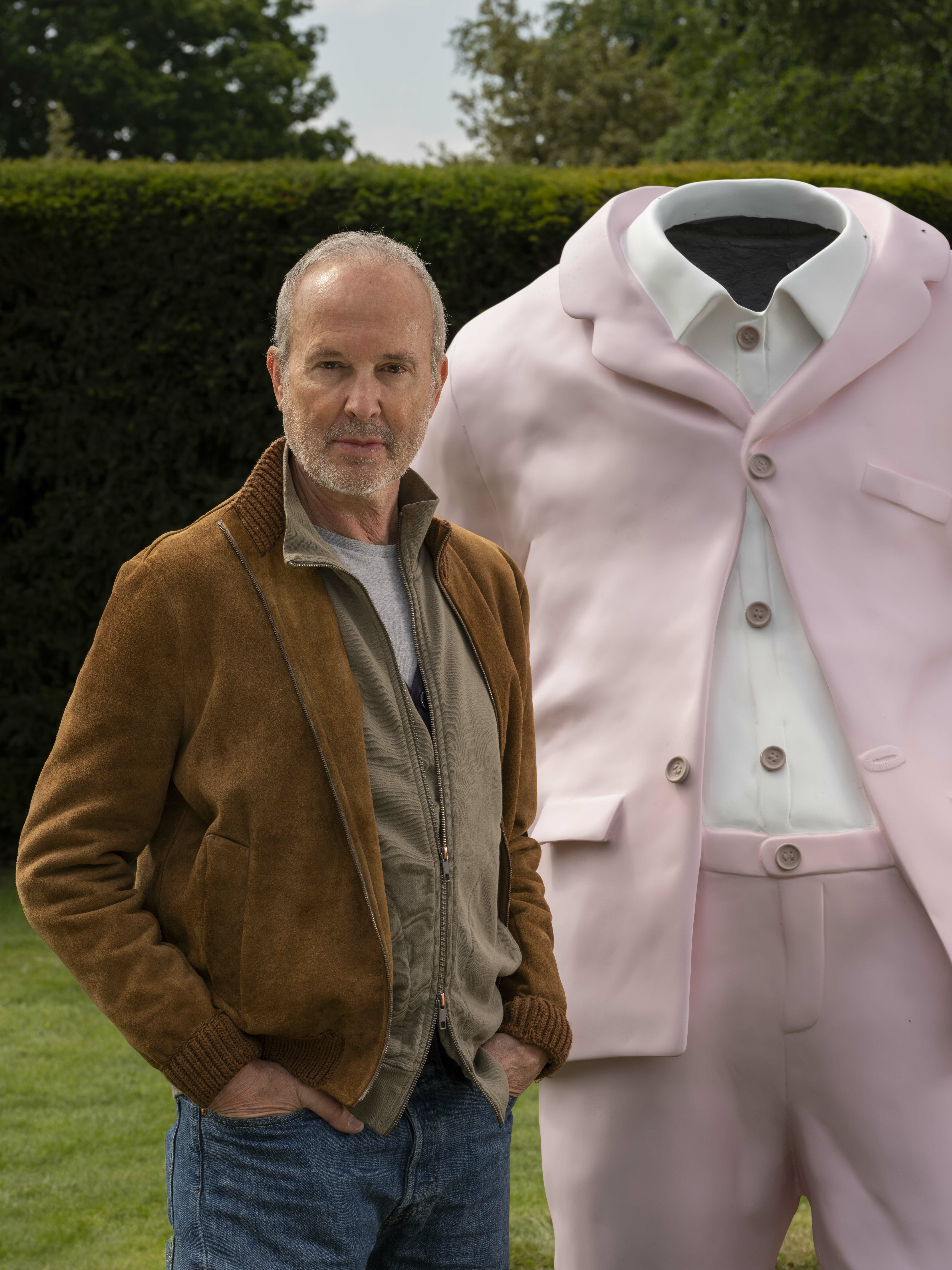 Man stood in front of sculpture of a pink suit